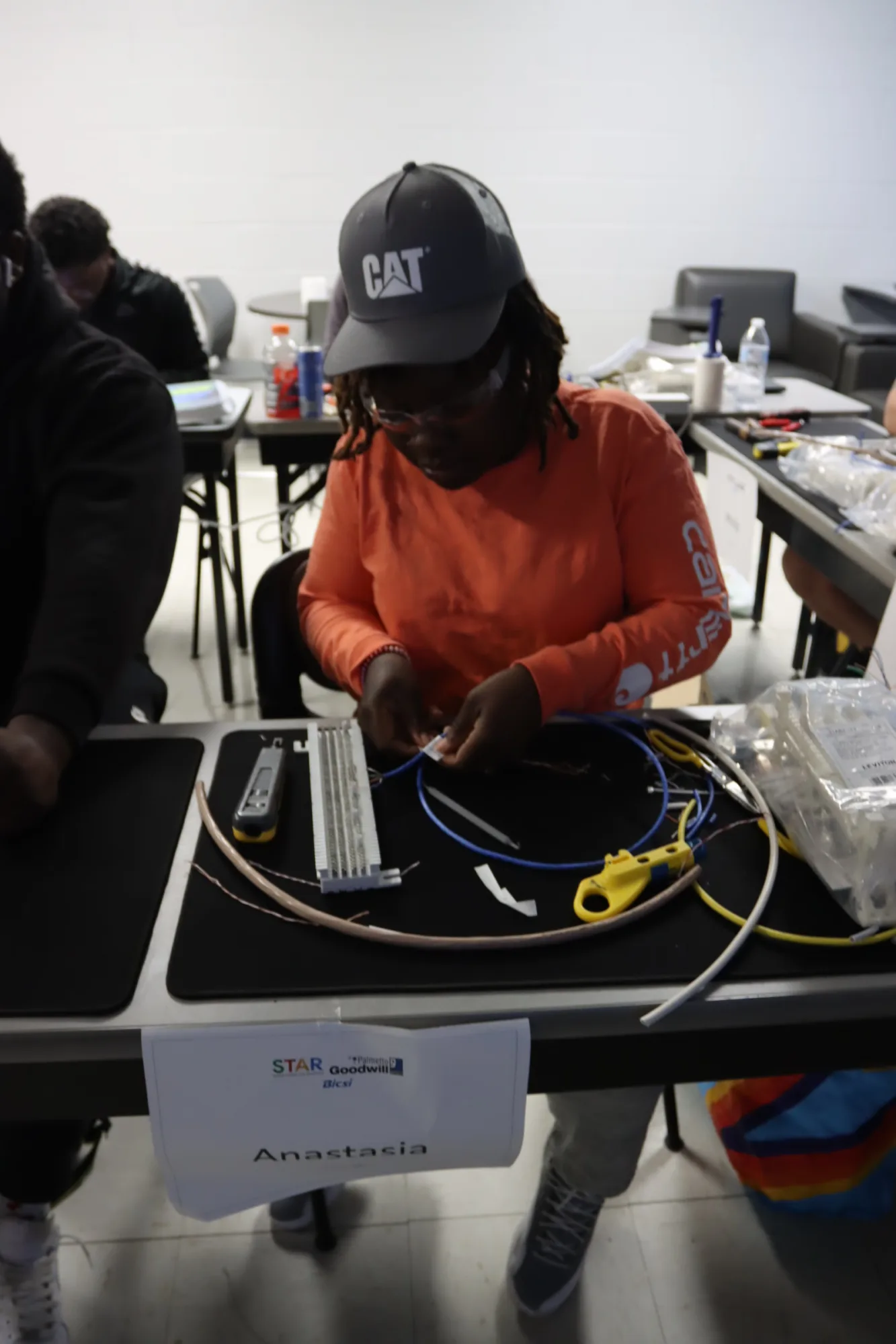 A student in the STAR program learning fiber optics, working with cables during a job training class.