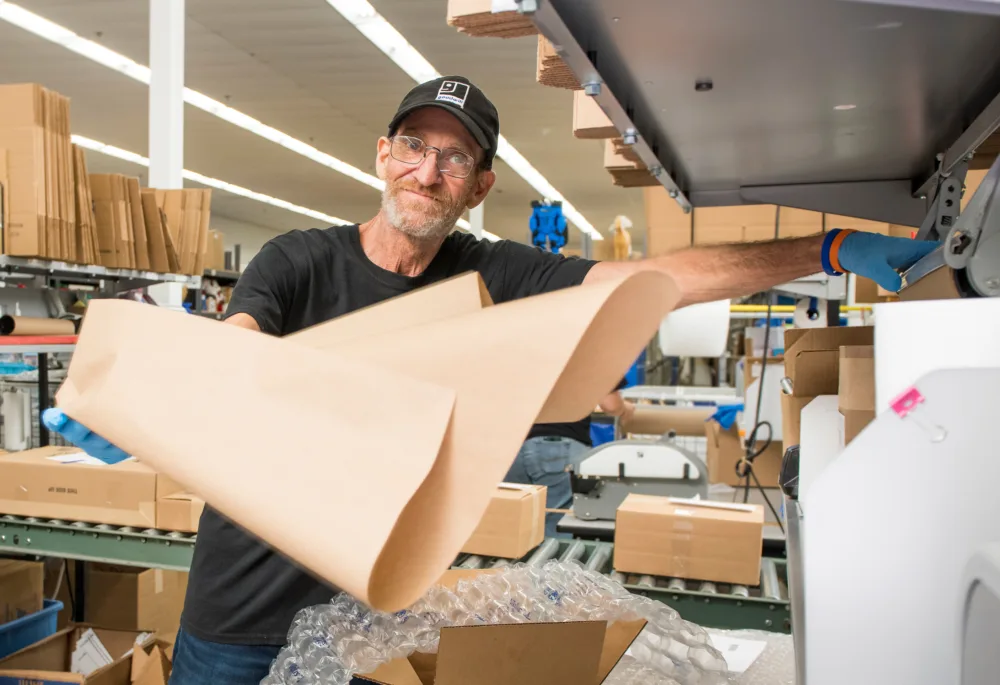 Mature volunteer helping with donation drive assistance in a Palmetto Goodwill processing center, contributing to the recycling mission.