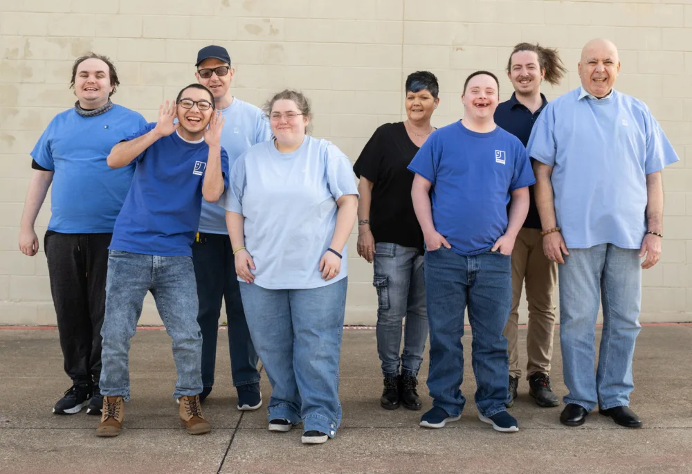 Diverse group of Palmetto Goodwill Enclave Program members standing together, symbolizing community inclusion and the success of the supported employment model.