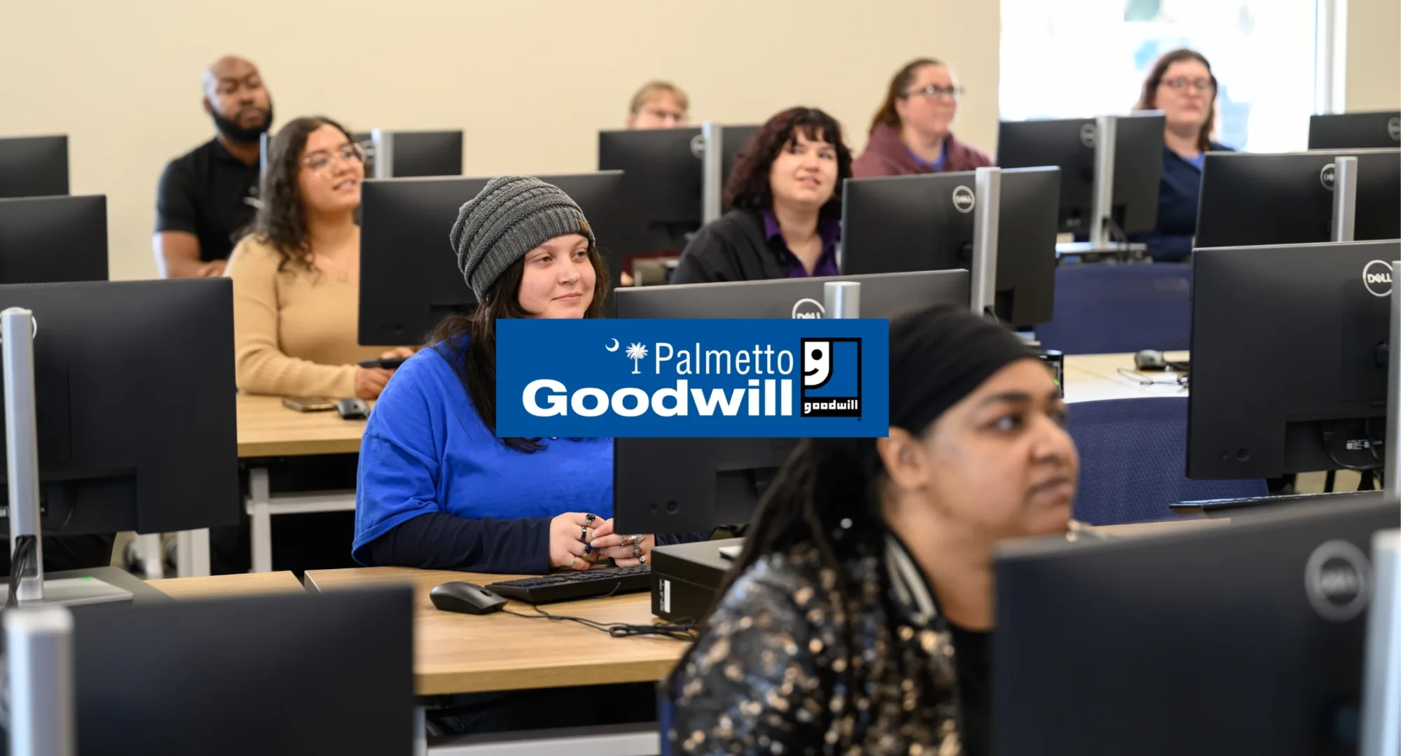 Palmetto Goodwill logo over a full classroom of job seekers receiving training, symbolizing the availability of free Google Certifications for digital skills training in SC.
