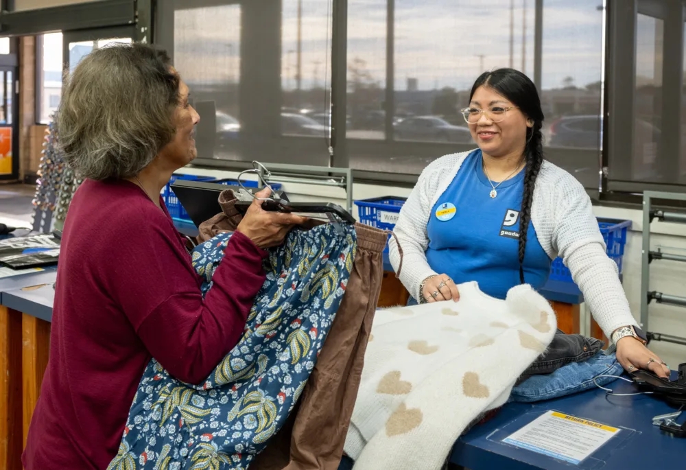 Palmetto Goodwill team member Cayla smiling while assisting a shopper at the checkout counter, demonstrating how every purchase at the best thrift store SC loves funds local job training.