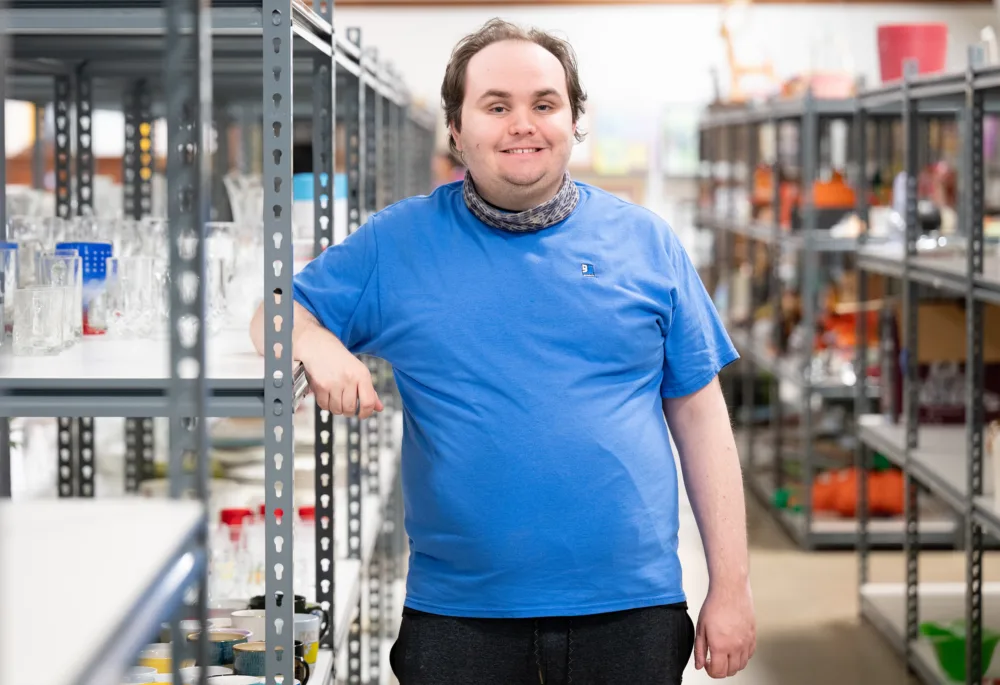 Palmetto Goodwill Enclave member working among retail shelving, showcasing the independence gained through supported, integrated employment.