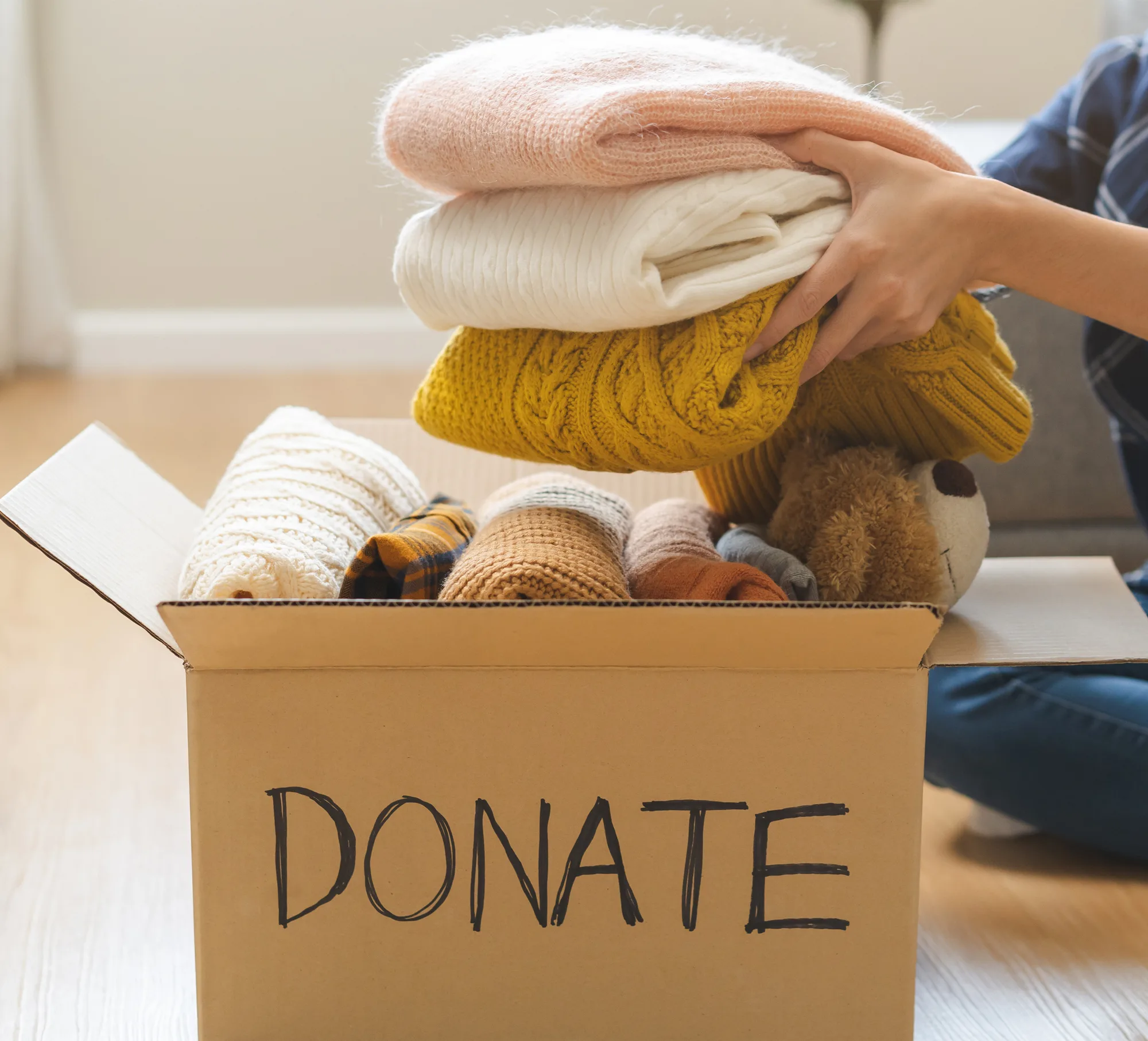 A cardboard box filled with clothing to be donated