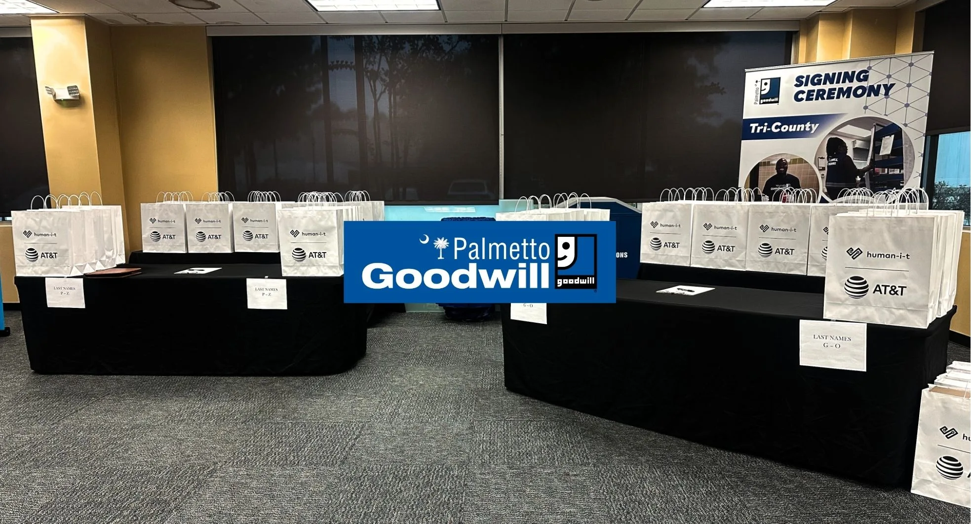 Rows of white donation bags from AT&T and human-i-t ready for distribution at a Palmetto Goodwill Tri-County signing ceremony to support digital equity.