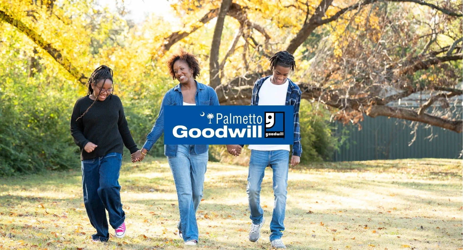 A family walks through a sunlit South Carolina park with a Palmetto Goodwill logo overlay (promoting sustainable thrifting in South Carolina).